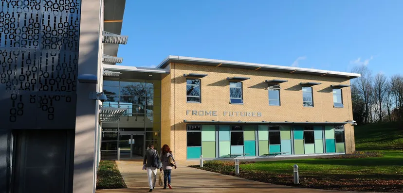 Il moderno edificio del Frome College con la scritta Frome Futures e due persone davanti all'ingresso.