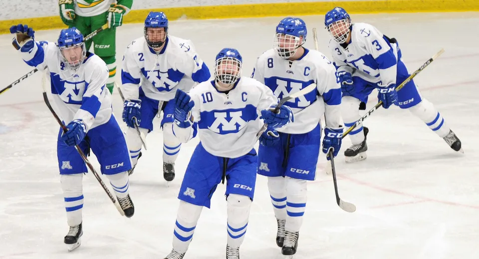 Studenti del Lisgar Collegiate Institute giocano a hockey su ghiaccio sulla pista con una porta verde e gialla.