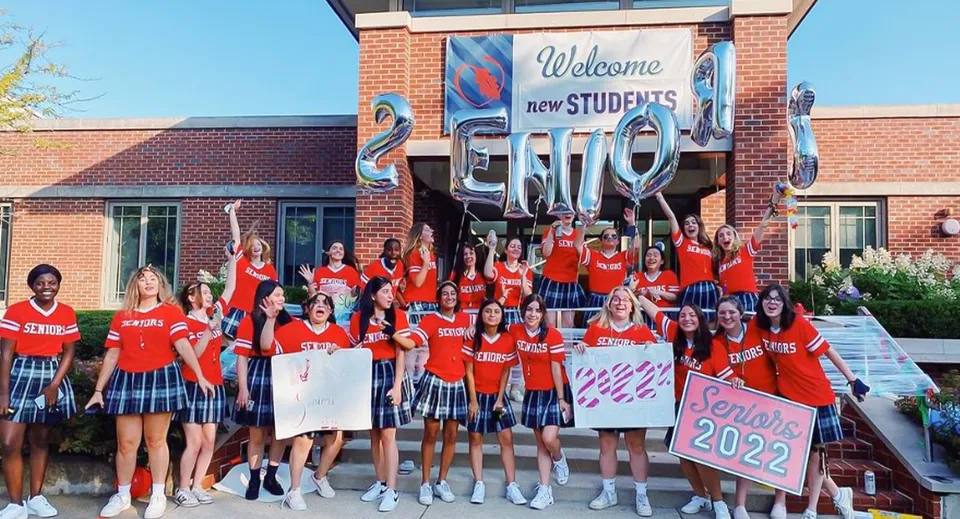 Studentesse e studenti della Woodlands Academy of the Sacred Heart accolgono le nuove studentesse e i nuovi studenti dell'annata 2022 davanti a un edificio in mattoni.