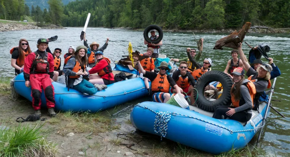 Studenti della L.V. Rogers Secondary School siedono su gommoni vicino alla riva del fiume con rifiuti raccolti.