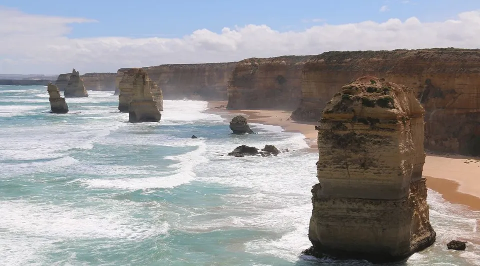 Le scogliere e le formazioni rocciose sull'oceano si vedono sotto un cielo nuvoloso, senza un riferimento diretto al Gilmore College.