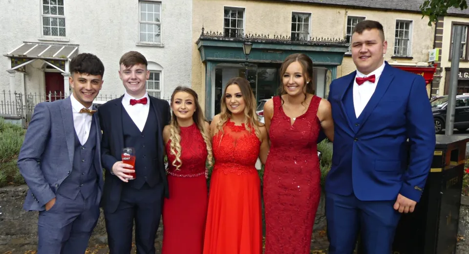 Un gruppo di cinque studenti e studentesse è in piedi davanti a un edificio nel campus del St. Fergal’s College.