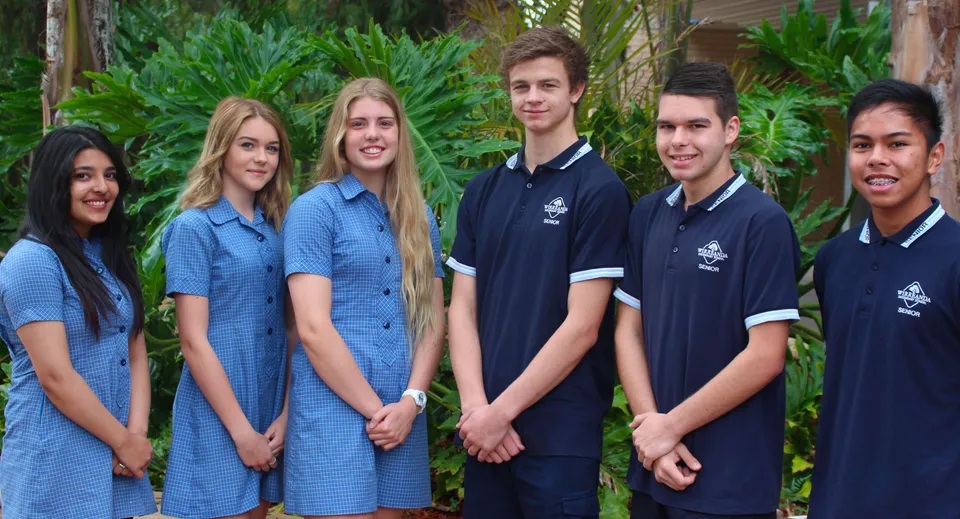 Un gruppo di studenti si trova nell'area esterna tropicale nel campus della Wirreanda Secondary School.