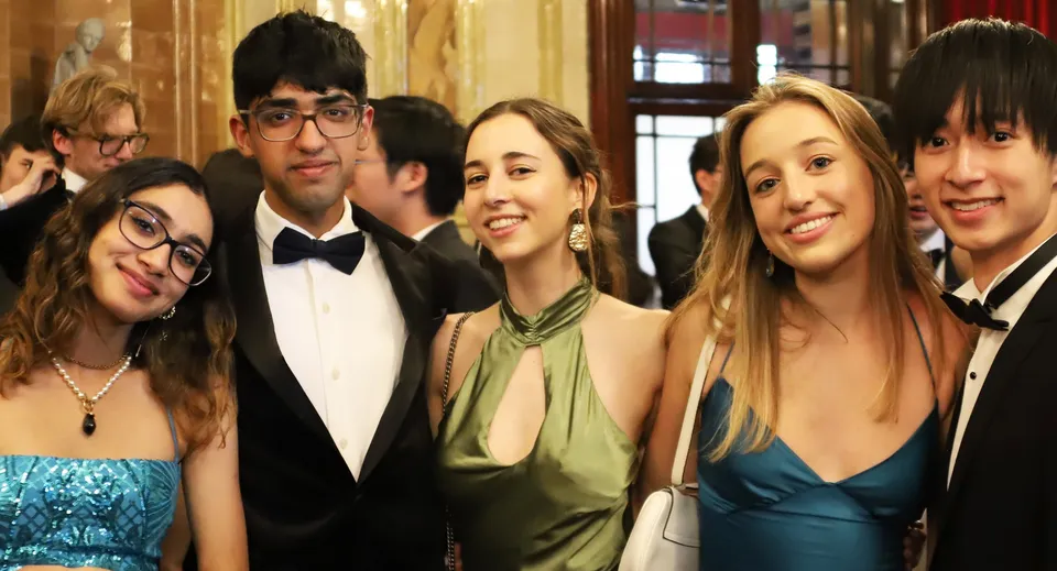 Un gruppo di studentesse e studenti della Westminster School durante un evento formale con uno sfondo decorativo.