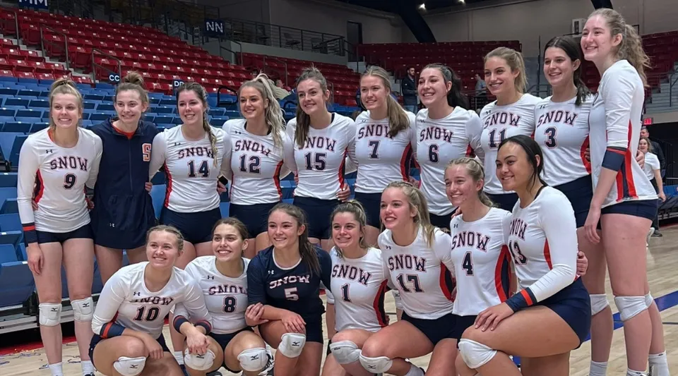 Un gruppo di giovani pallavoliste posa in maglia bianca del Snow College su un campo da basket.