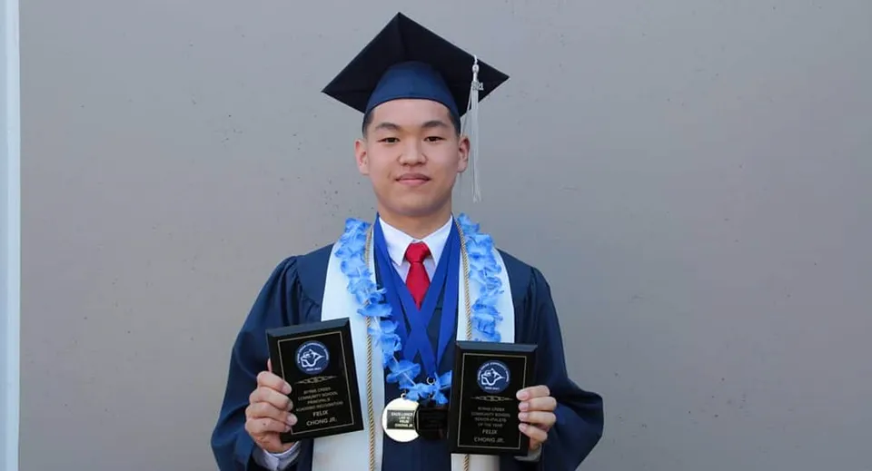 Un diplomato della Byrne Creek School è in piedi davanti a uno sfondo grigio e tiene in mano due premi.