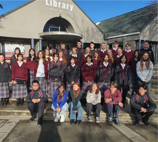 Große Schülergruppe in Schuluniform vor der Schulbibliothek in Neuseeland