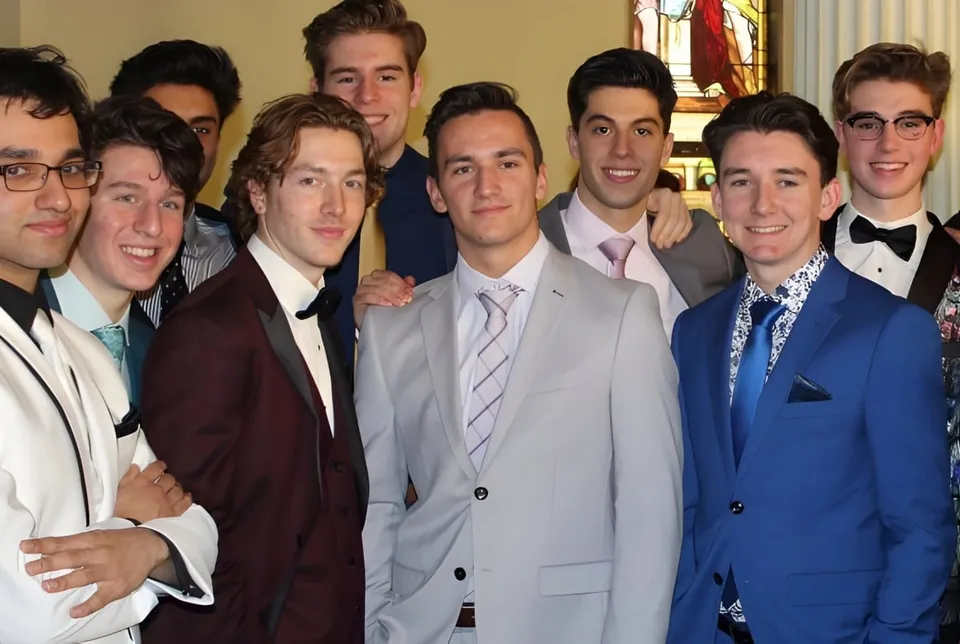 Un grupo de hombres jóvenes posa junto en un entorno formal en el campus de la Riverside Secondary School.