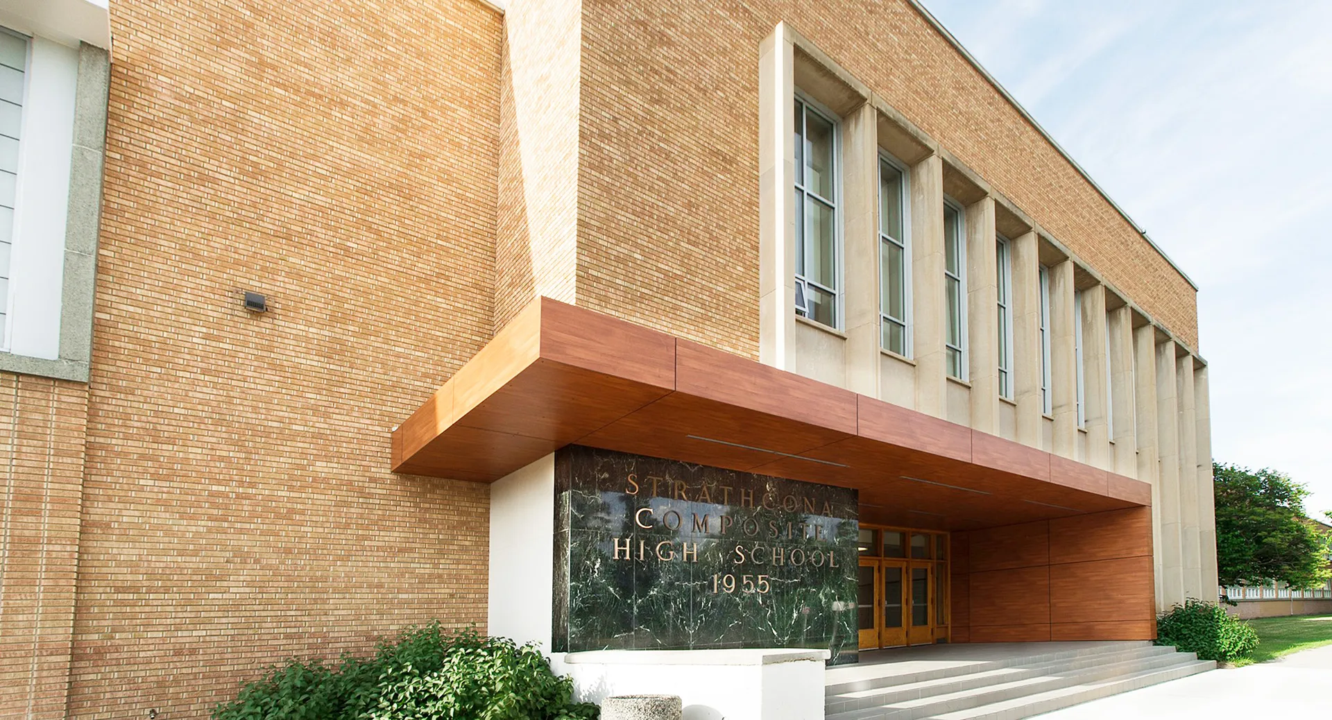 L'edificio in mattoni con l'ingresso ben visibile della Strathcona High School è circondato da aree verdi.