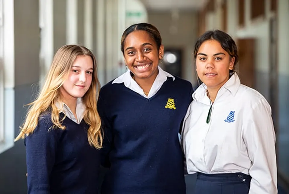 Tre studenti e studentesse si trovano insieme nel corridoio del Whanganui Girls’ College.