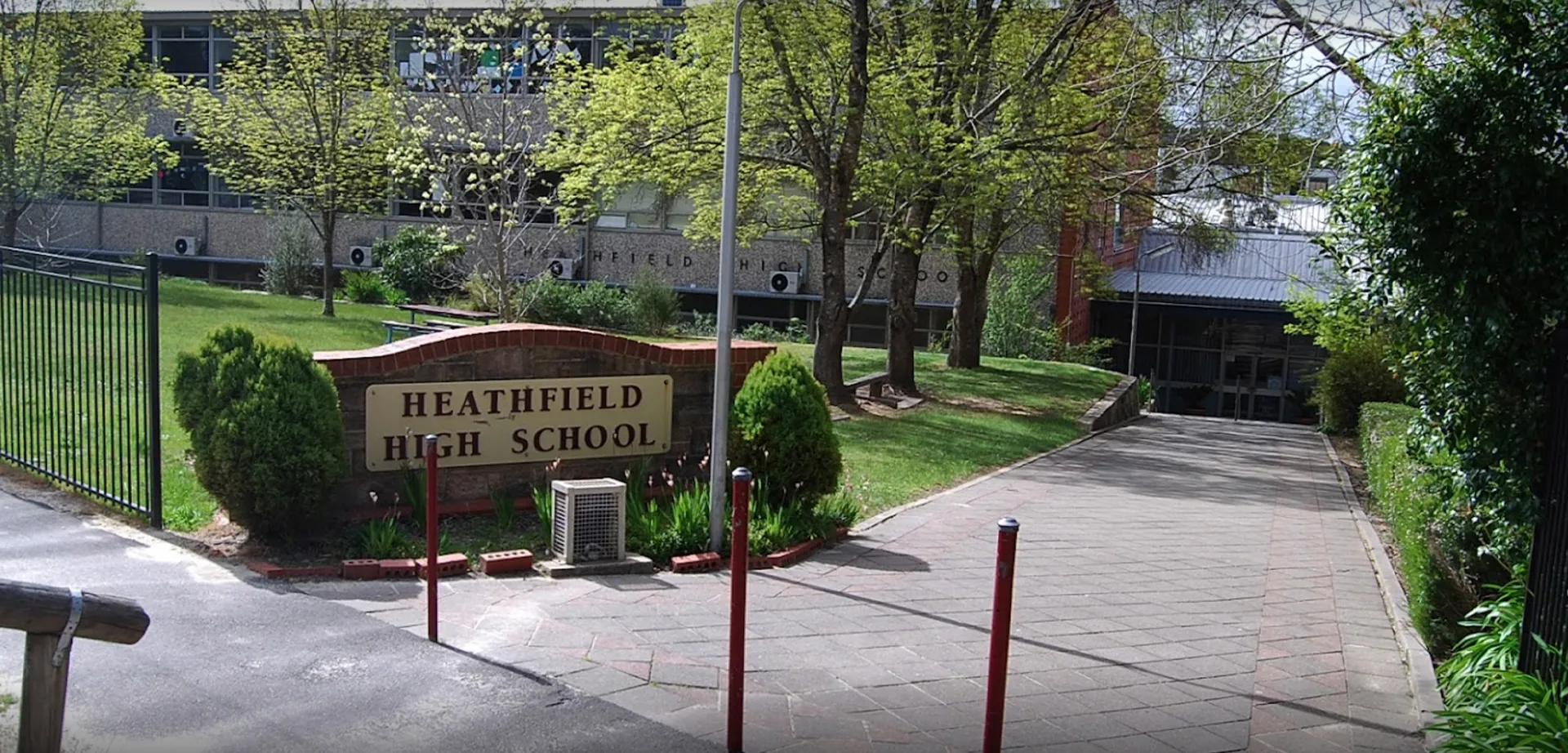 L'ingresso della Heathfield High School con un cartello, alberi e un viale pavimentato.