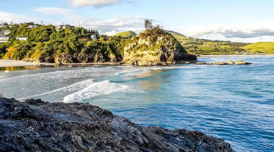 Il paesaggio costiero sul mare con scogliere e vegetazione nei dintorni del Kaikorai Valley College.