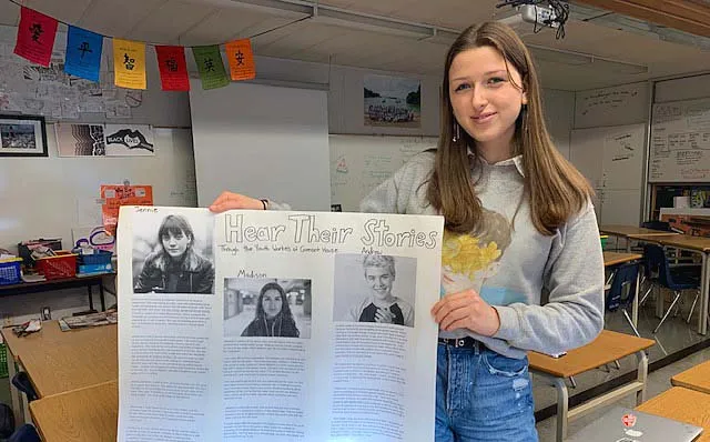 Una estudiante muestra en clase en Handsworth Secondary School un póster con diferentes peinados e información al respecto.