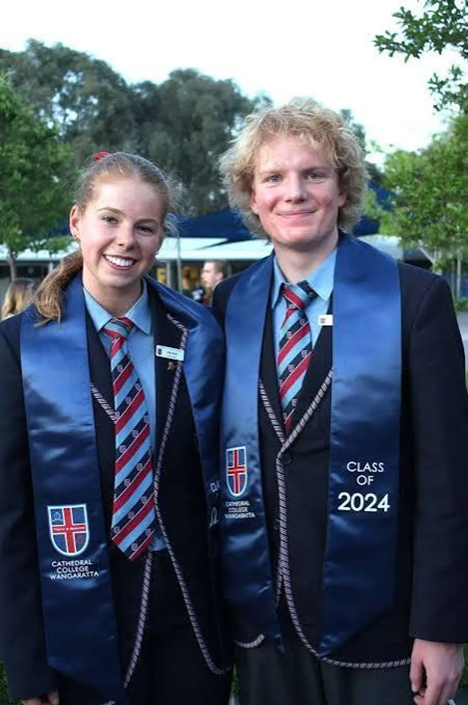 Due studenti del Cathedral College Wangaratta sorridono indossando la divisa scolastica e le fasce della Class of 2024.