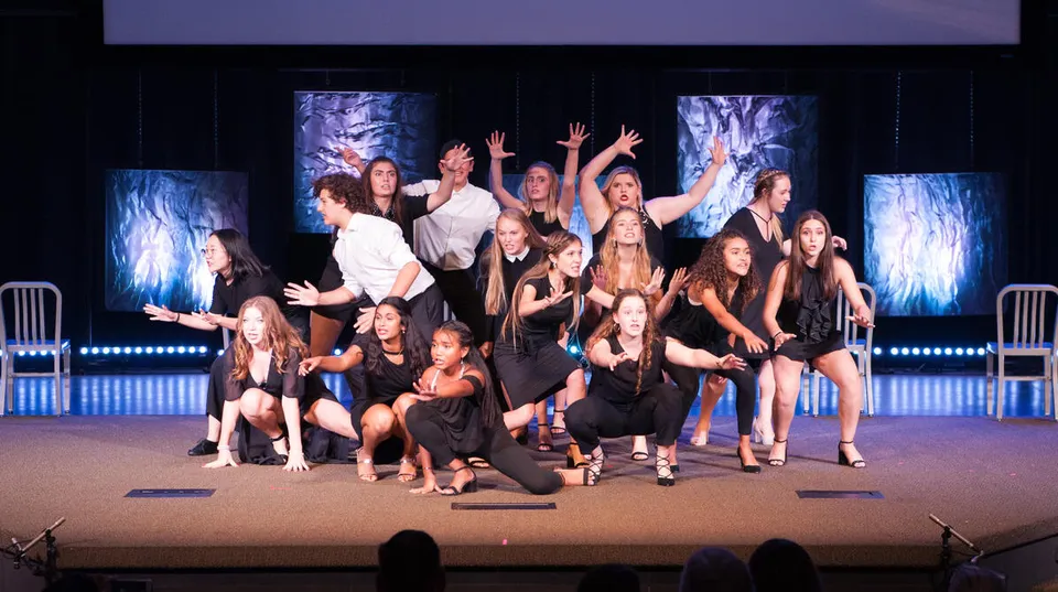 Studenti della Windermere Preparatory School si esibiscono in una performance di danza dinamica sul palco con illuminazione colorata.