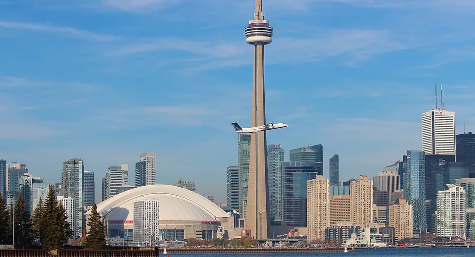 Un'alta torre di comunicazione si erge davanti allo skyline di moderni grattacieli sul terreno della Twin Lakes Secondary School.
