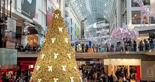 Gran árbol de Navidad decorado con lazos blancos en el interior de un centro comercial