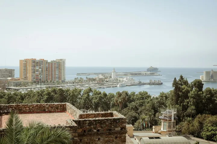 Blick von oben auf Málaga mit Hafen, Altstadt und Mittelmeer