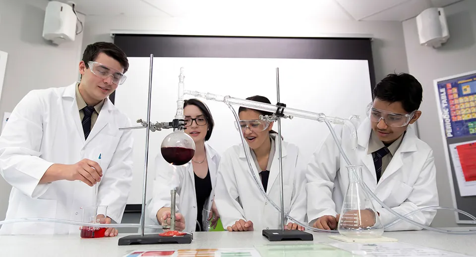 Studenti del Stretton State College eseguono un esperimento in laboratorio con attrezzature scientifiche.