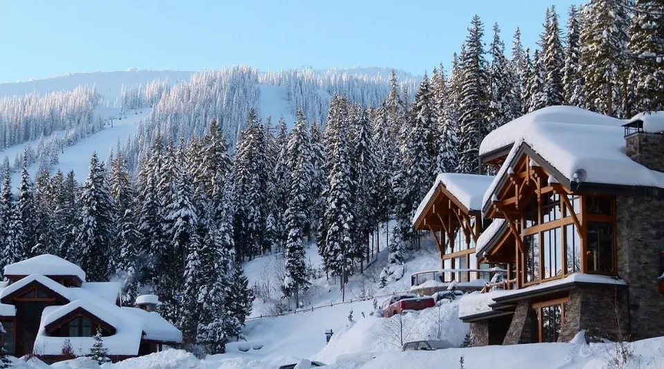 Un paesaggio montano innevato con una baita in legno tra i pini sul terreno della Donald A. Wilson School.