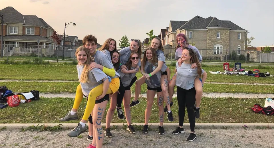 Un gruppo di studentesse si trova su un prato davanti a edifici residenziali all'interno del campus della Bradford District High School.