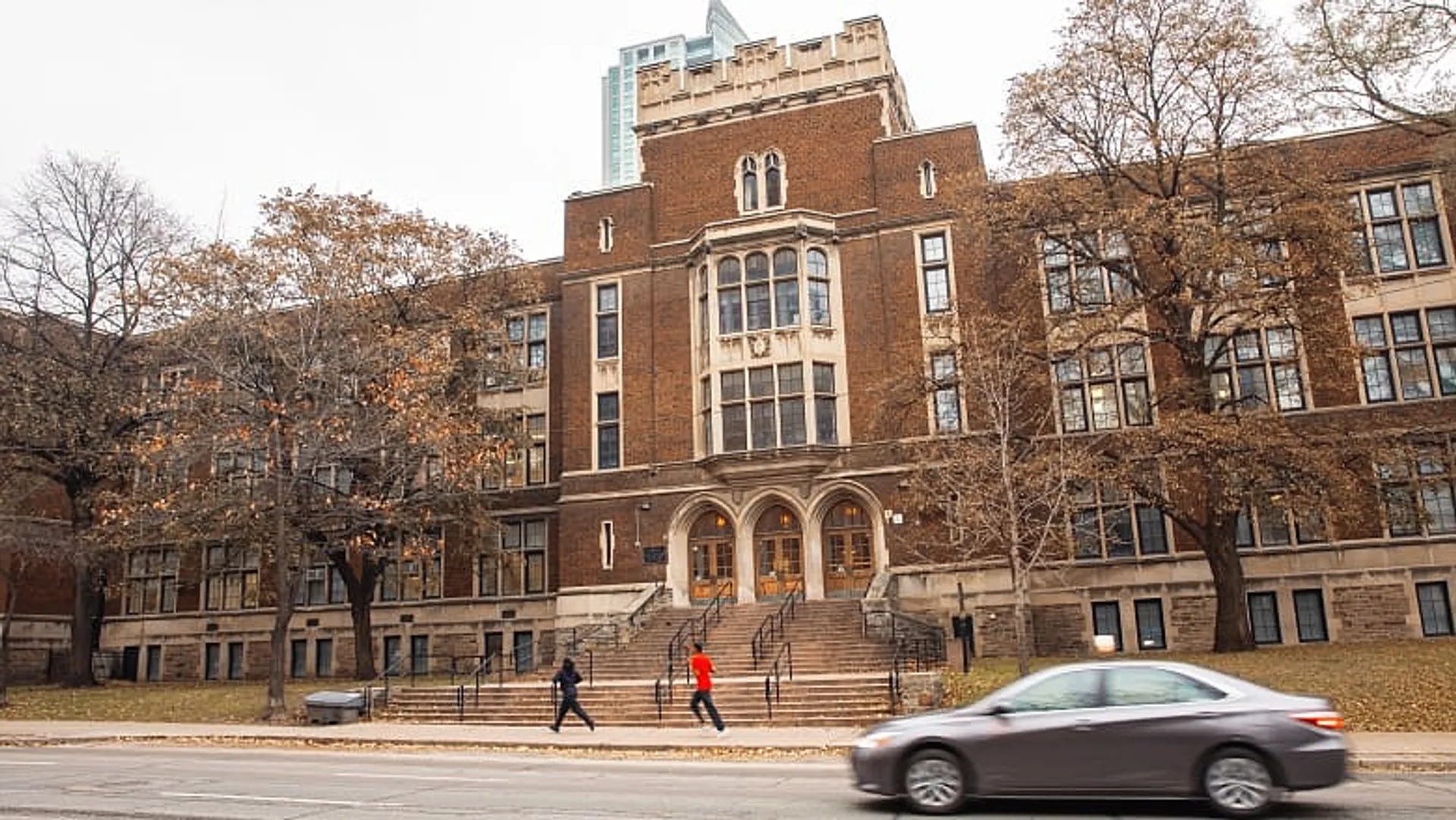 Il grande edificio in mattoni con la torre ben visibile appartiene al Jarvis Collegiate Institute ed è circondato da alberi.