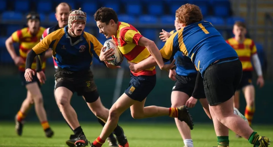 Un alunno della Drogheda Grammar School corre con il pallone durante una partita di rugby.