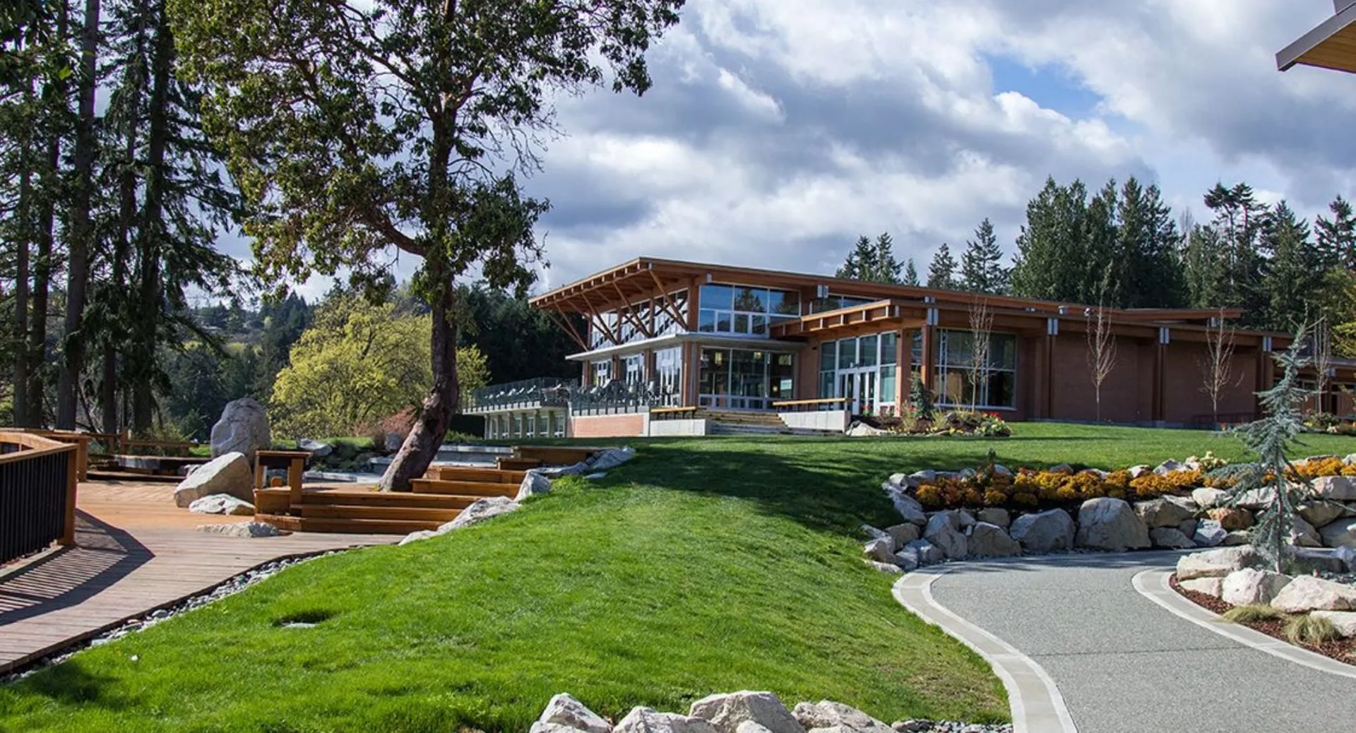 Una moderna casa in legno nel campus della Brentwood College School circondata da aree verdi e da un prato curato.