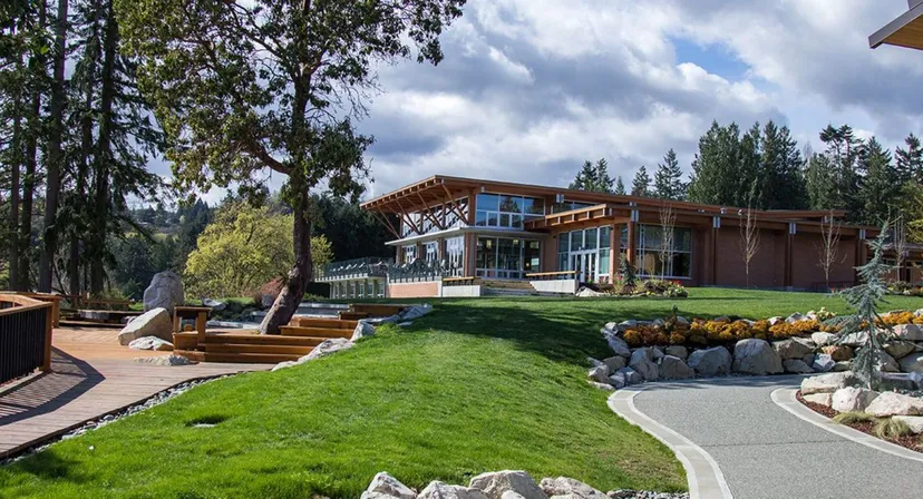 Una moderna casa in legno nel campus della Brentwood College School circondata da aree verdi e da un prato curato.