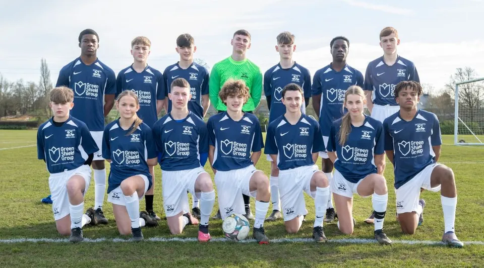 Un gruppo di studenti della Moorland School posa insieme su un campo da calcio.