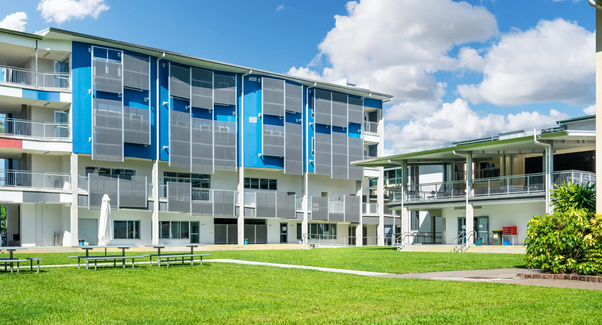 L'edificio moderno a più piani della Bush Post Primary School è circondato da un prato e da alberi.