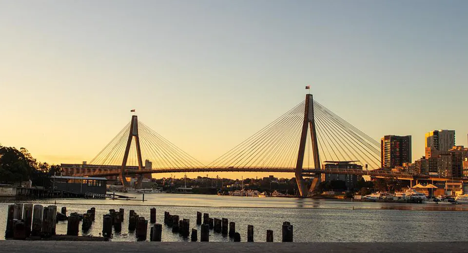 Un ponte sospeso su un fiume con vista sulla città al tramonto vicino al Chancellor State College.