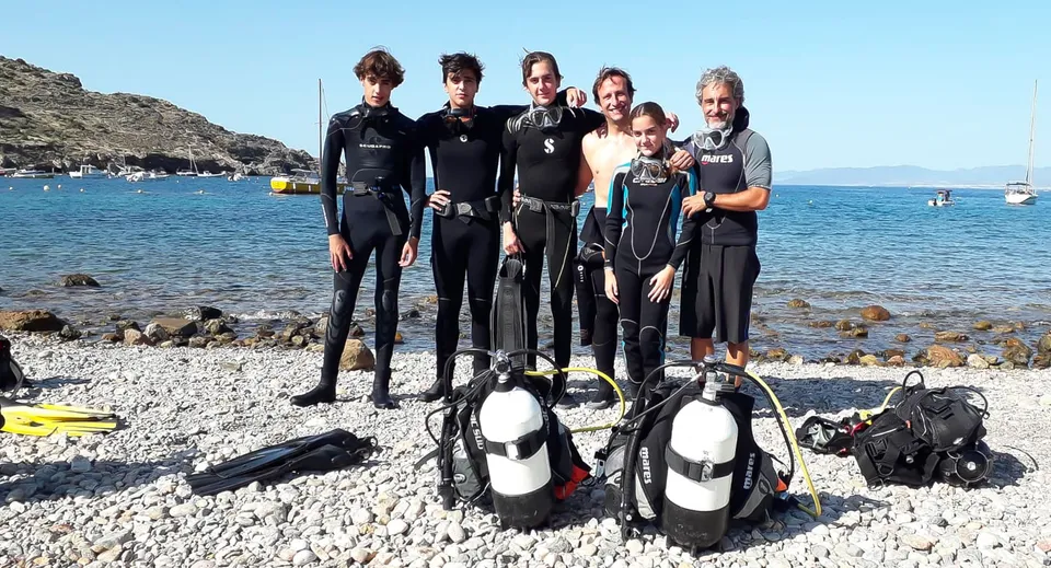 Studenti della International School San Patricio Toledo si preparano a un'immersione su una spiaggia rocciosa.