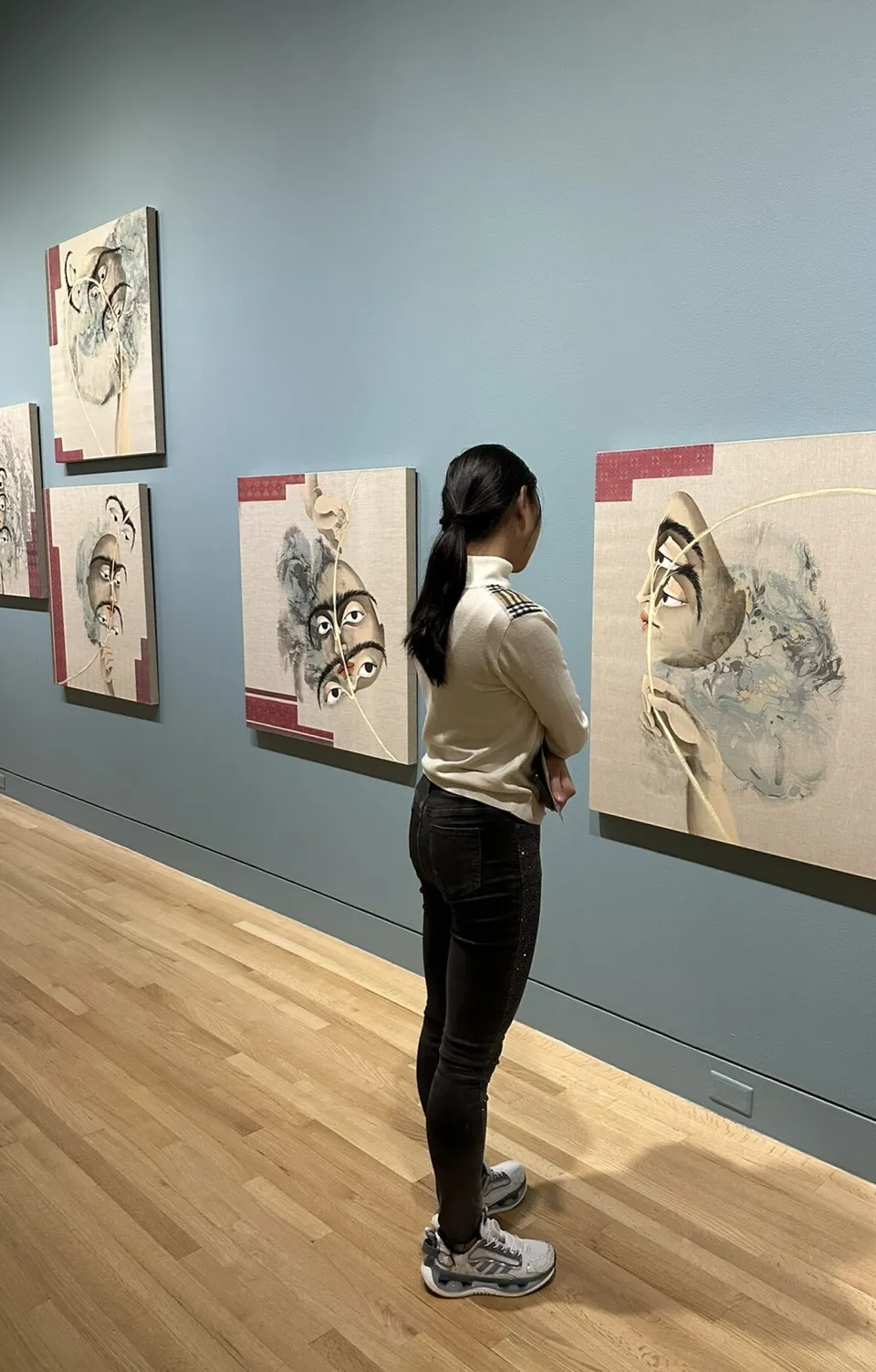 Una persona osserva diverse opere d'arte incorniciate in una galleria nel campus della Washington Preparatory School.