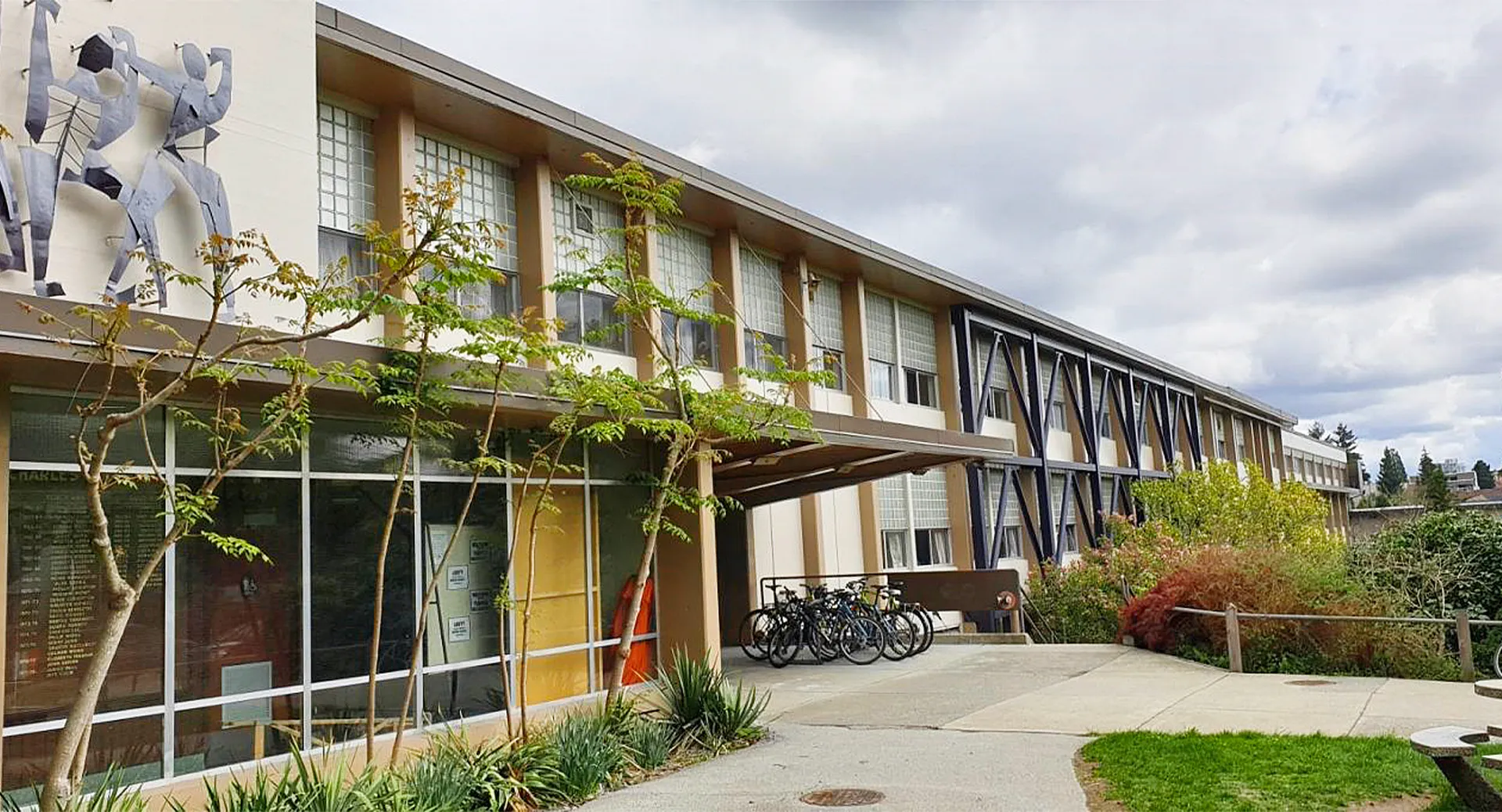 L'edificio della Sir Charles Tupper Secondary School con grandi vetrate, giovani alberi e biciclette parcheggiate.