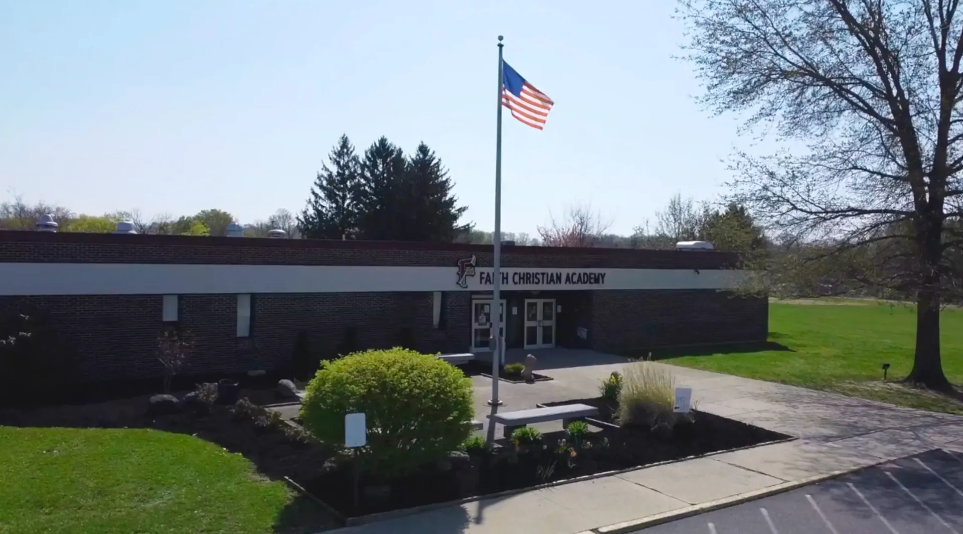 L'edificio principale della Faith Christian Academy (PA) con una bandiera americana nell'area esterna ben curata.