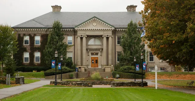 Il storico edificio principale della Brewster Academy si trova circondato da alberi con i colori autunnali su un prato ben tenuto.