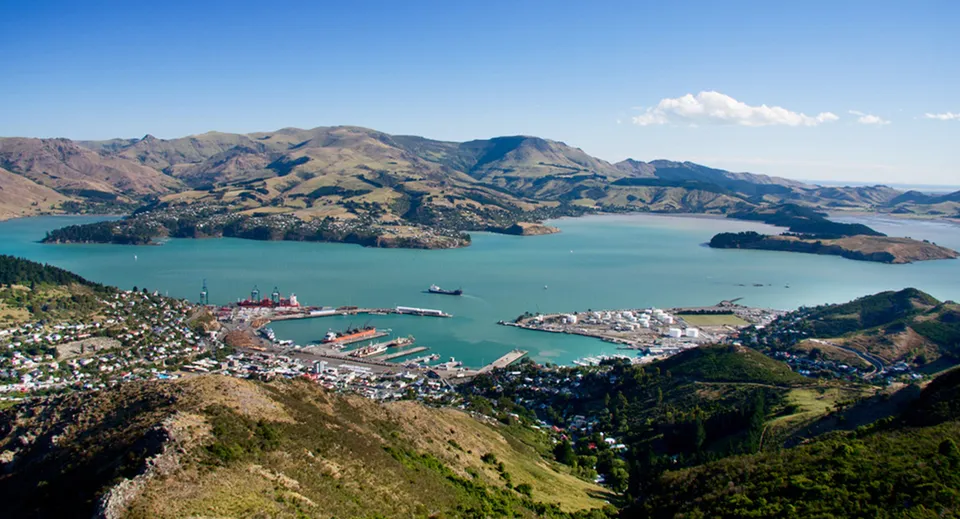 Il porto di una città costiera con montagne e acqua turchese sullo sfondo, vicino alla Burnside High School.