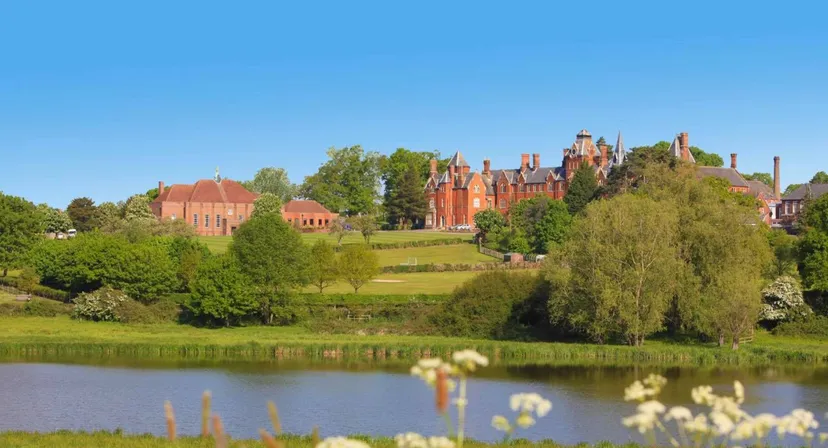 Il castello nel campus del Framlingham College è circondato da un laghetto e da un verde paesaggio.