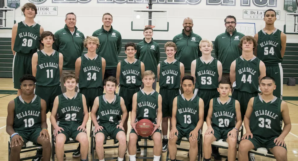 La squadra di pallacanestro della Balmoral State High School posa in maglia verde e nera nella palestra.