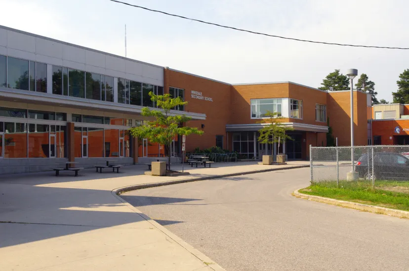 L'edificio moderno a più piani della Innisdale Secondary School con pareti in vetro ed elementi di facciata arancioni e grigi.
