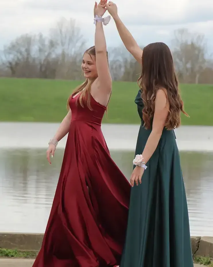 Due studentesse in abito da sera al ballo di fine anno vicino a un lago