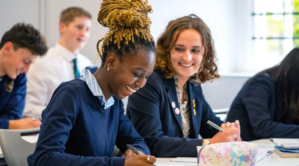 Un gruppo di studenti lavora insieme ai banchi in un'aula della Norwich School.