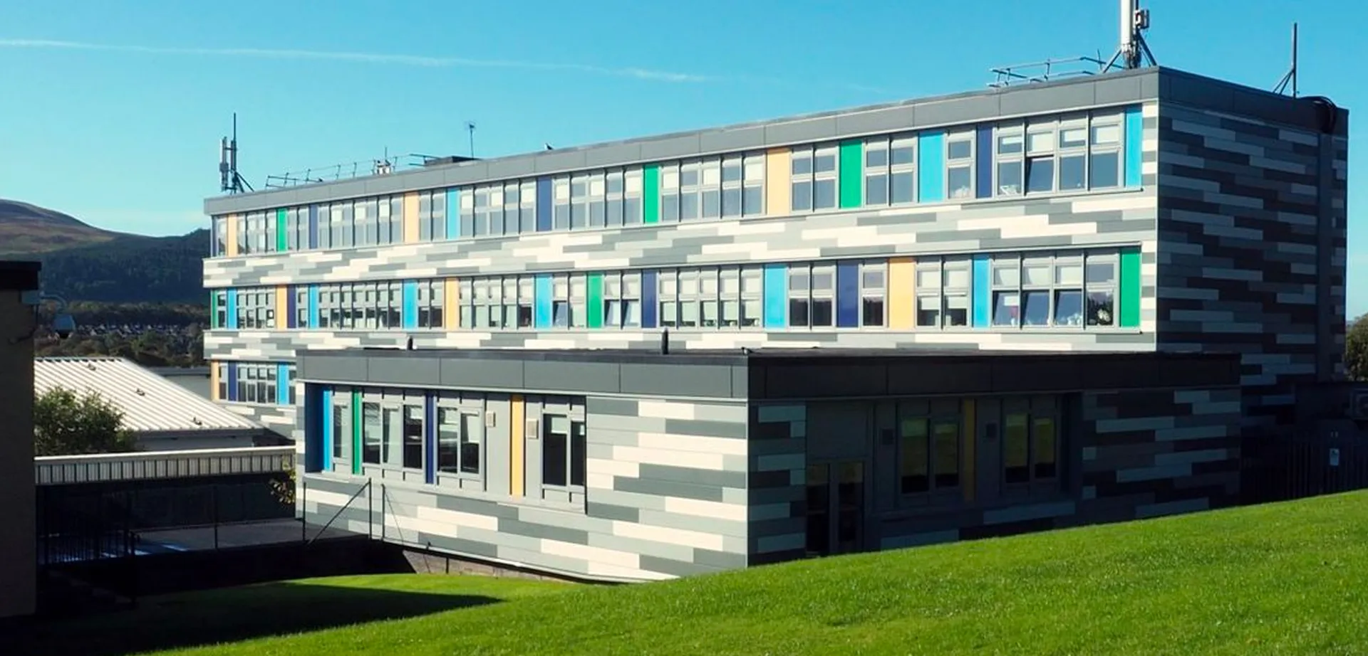 L'edificio moderno a più piani con una facciata geometrica colorata all'interno del campus della Firrhill High School.