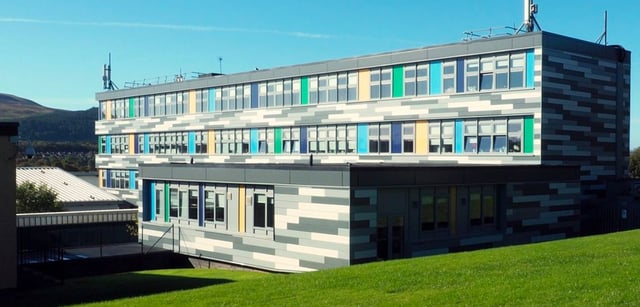 L'edificio moderno a più piani con una facciata geometrica colorata all'interno del campus della Firrhill High School.