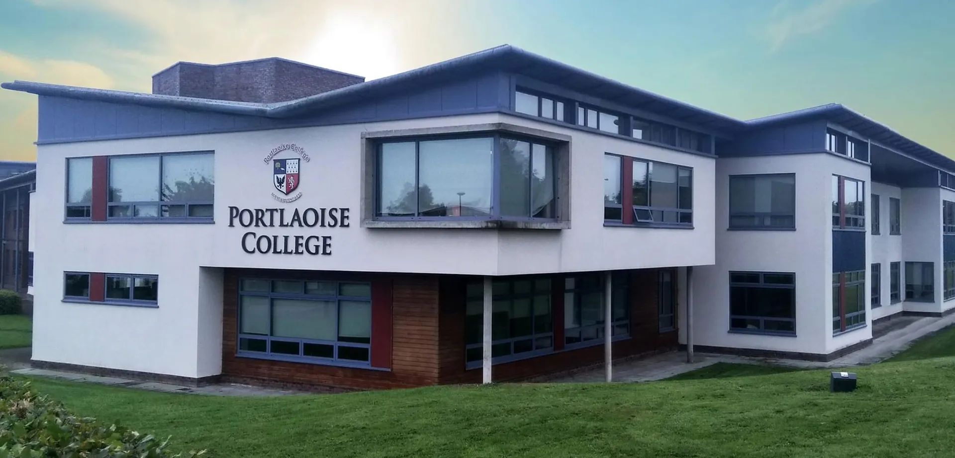 L'edificio moderno a più piani del Portlaoise College è circondato da un'area verde in primo piano.