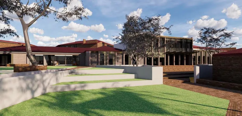 L'edificio moderno a più piani della Aberfoyle Park High School, con tetto rosso e facciata a vetri, è circondato da aree verdi e alberi.