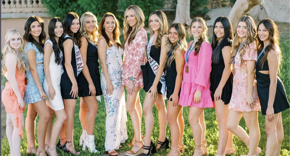 Un gruppo di giovani donne in abiti colorati posa nel verde nel campus della Hamilton High School.