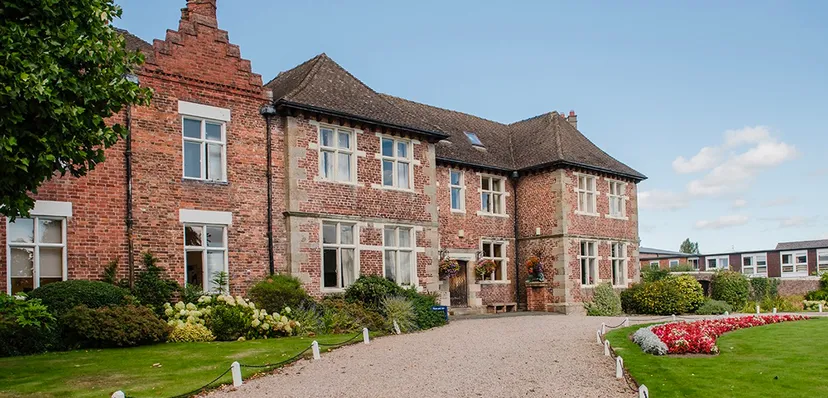 L'edificio in mattoni della Moreton Hall School è circondato da un giardino ben curato con fiori colorati.