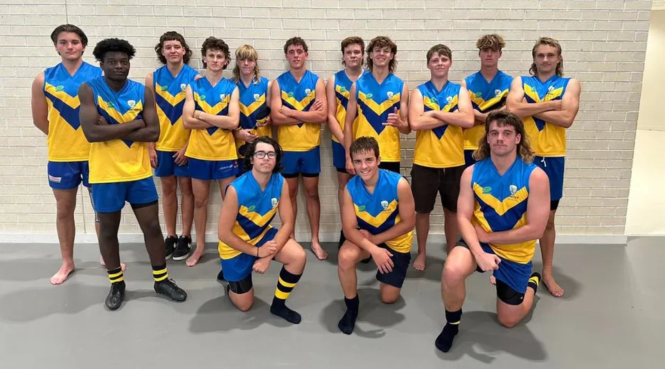 Un gruppo di studenti del Yanchep Secondary College sta insieme davanti a una parete bianca con uniformi scolastiche blu e gialle.